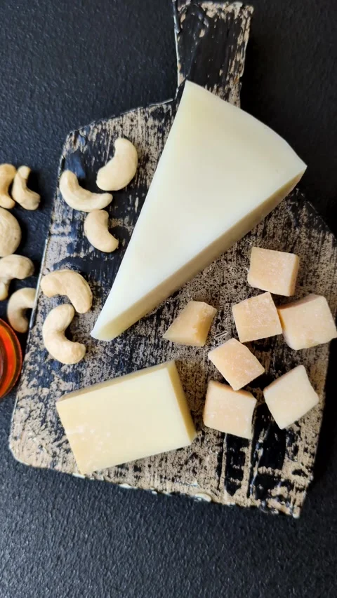 Aged cheese in a triangular block with jam, figs, and nuts. Aged cheese Stock Footage 336245111