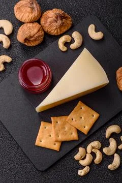 Aged cheese in a triangular block with jam, figs, and nuts. Aged cheese Stock Photos
