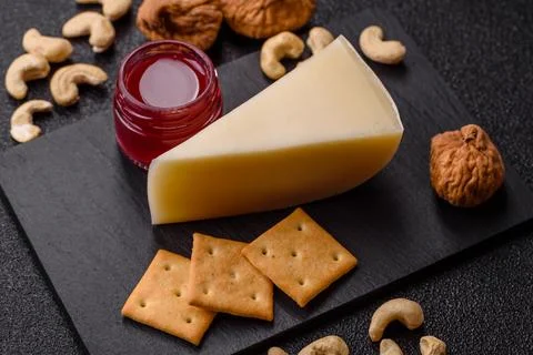 Aged cheese in a triangular block with jam, figs, and nuts. Aged cheese Stock Photos