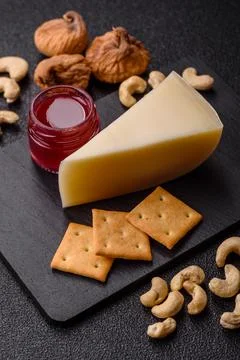 Aged cheese in a triangular block with jam, figs, and nuts. Aged cheese Stock Photos