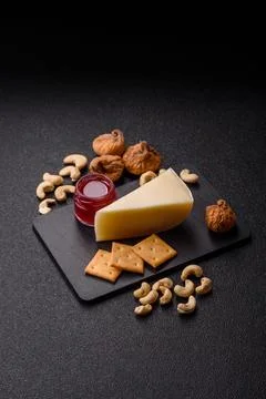 Aged cheese in a triangular block with jam, figs, and nuts. Aged cheese Stock Photos