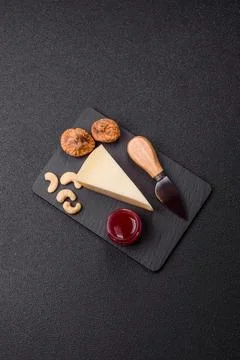 Aged cheese in a triangular block with jam, figs, and nuts. Aged cheese Stock Photos