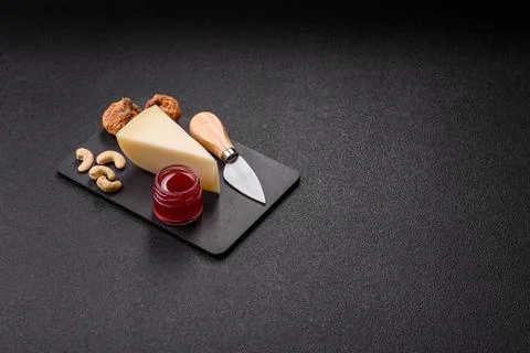 Aged cheese in a triangular block with jam, figs, and nuts. Aged cheese Stock Photos