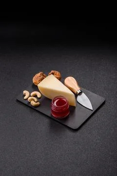 Aged cheese in a triangular block with jam, figs, and nuts. Aged cheese Stock Photos