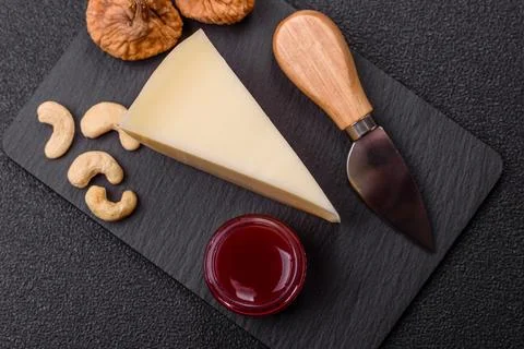 Aged cheese in a triangular block with jam, figs, and nuts. Aged cheese Stock Photos