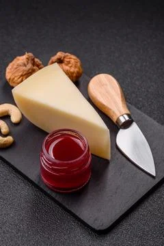 Aged cheese in a triangular block with jam, figs, and nuts. Aged cheese Stock Photos