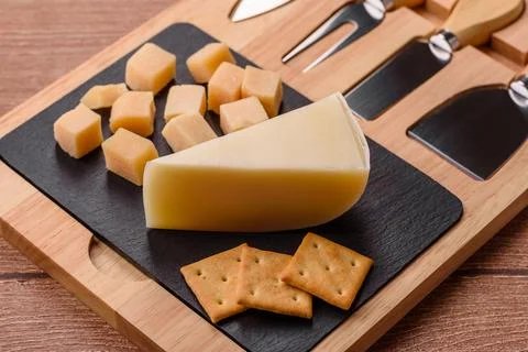 Aged cheese in a triangular block with jam, figs, and nuts. Aged cheese Stock Photos