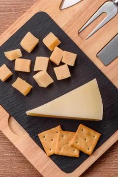 Aged cheese in a triangular block with jam, figs, and nuts. Aged cheese Stock Photos