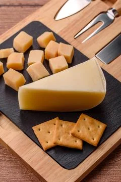Aged cheese in a triangular block with jam, figs, and nuts. Aged cheese Stock Photos