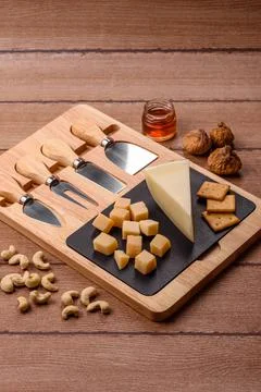 Aged cheese in a triangular block with jam, figs, and nuts. Aged cheese Stock Photos