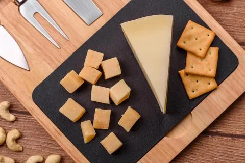 Aged cheese in a triangular block with jam, figs, and nuts. Aged cheese Stock Photos