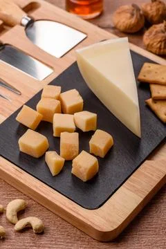 Aged cheese in a triangular block with jam, figs, and nuts. Aged cheese Stock Photos