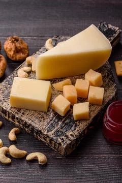 Aged cheese in a triangular block with jam, figs, and nuts. Aged cheese Stock Photos