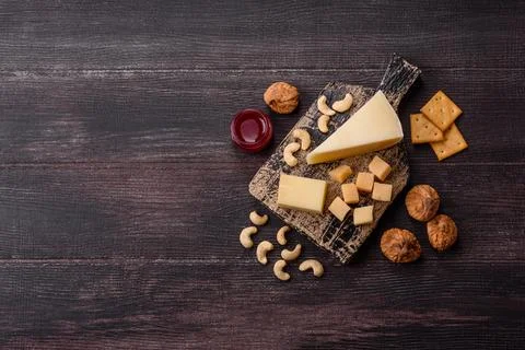 Aged cheese in a triangular block with jam, figs, and nuts. Aged cheese Stock Photos