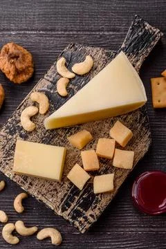 Aged cheese in a triangular block with jam, figs, and nuts. Aged cheese Stock Photos