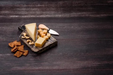 Aged cheese in a triangular block with jam, figs, and nuts. Aged cheese Stock Photos