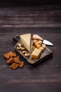 Aged cheese in a triangular block with jam, figs, and nuts. Aged cheese Stock Photos