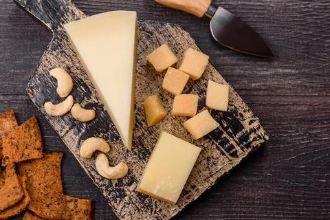 Aged cheese in a triangular block with jam, figs, and nuts. Aged cheese Stock Photos