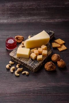 Aged cheese in a triangular block with jam, figs, and nuts. Aged cheese Stock Photos