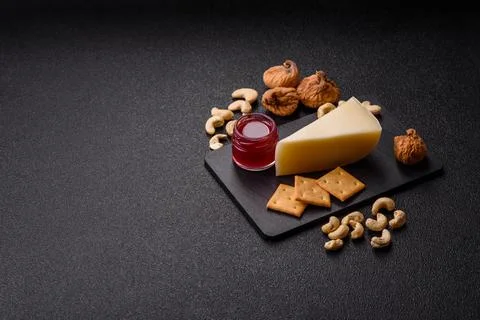 Aged cheese in a triangular block with jam, figs, and nuts. Aged cheese Stock Photos