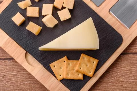 Aged cheese in a triangular block with jam, figs, and nuts. Aged cheese Stock Photos