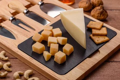 Aged cheese in a triangular block with jam, figs, and nuts. Aged cheese Stock Photos