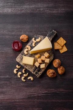 Aged cheese in a triangular block with jam, figs, and nuts. Aged cheese Stock Photos