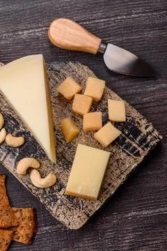 Aged cheese in a triangular block with jam, figs, and nuts. Aged cheese Stock Photos
