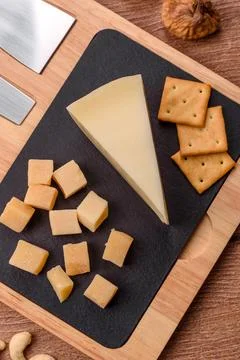 Aged cheese in a triangular block with jam, figs, and nuts. Aged cheese Stock Photos
