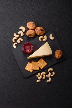 Aged cheese in a triangular block with jam, figs, and nuts. Aged cheese Stock Photos