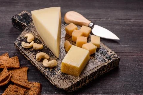 Aged cheese in a triangular block with jam, figs, and nuts. Aged cheese Stock Photos