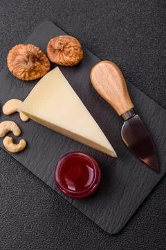 Aged cheese in a triangular block with jam, figs, and nuts. Aged cheese Stock Photos