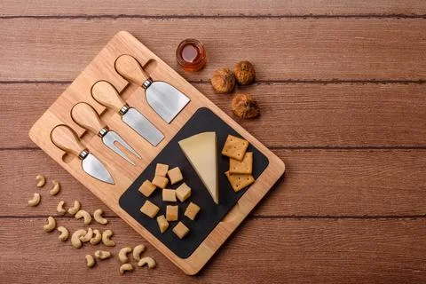 Aged cheese in a triangular block with jam, figs, and nuts. Aged cheese Stock Photos
