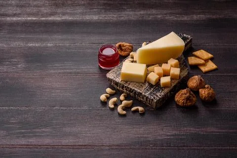 Aged cheese in a triangular block with jam, figs, and nuts. Aged cheese Stock Photos