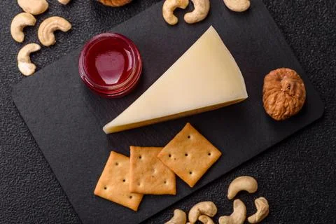 Aged cheese in a triangular block with jam, figs, and nuts. Aged cheese Stock Photos