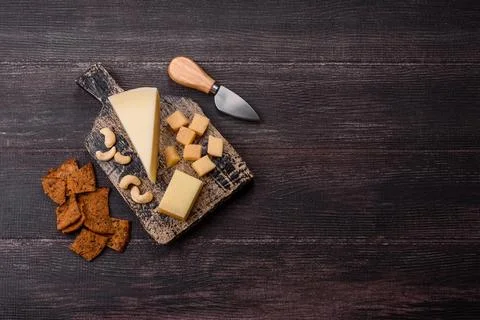 Aged cheese in a triangular block with jam, figs, and nuts. Aged cheese Stock Photos