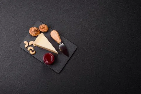 Aged cheese in a triangular block with jam, figs, and nuts. Aged cheese Stock Photos