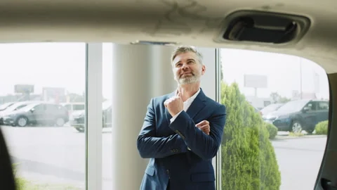 Aged client looking inside the luggage compartment of the vehicle. Stylish Stock Footage 240241597