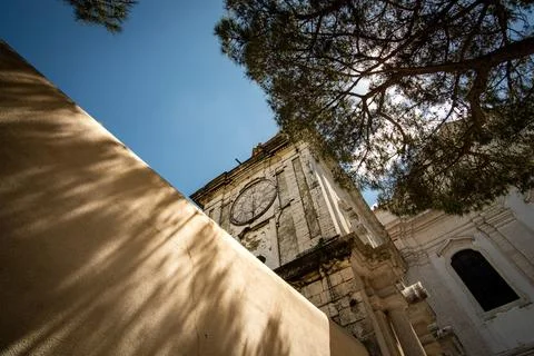 Aged clock and shadowed wall at Graca church in Lisbon, Portugal Stock Photos