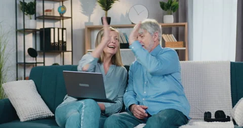 Aged couple looking at computer screen and giving high five Video stock 154194763