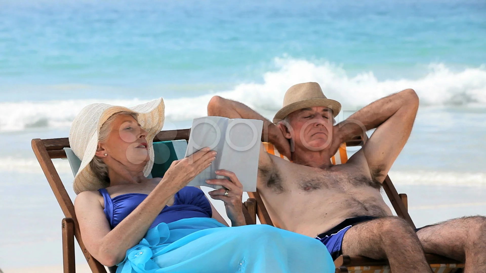 Aged couple relaxing on beach chairs