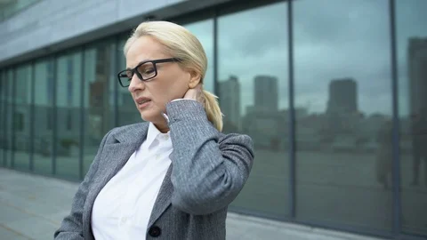 Aged female employee feeling sharp pain in neck outdoor, inflammation result Stock-Footage 119022542