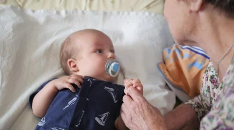 Aged granny playing and talking to the grandchild. Handheld shot Stock Footage 68991156
