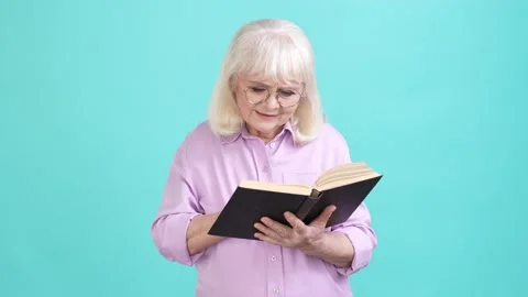Aged lady interested read textbook thoughtful isolated cyan color background Stock Footage 196148044