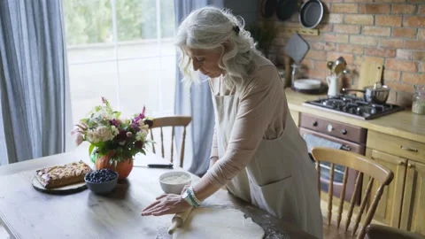 Aged lady roll out round dough piece Stock Footage 153377095