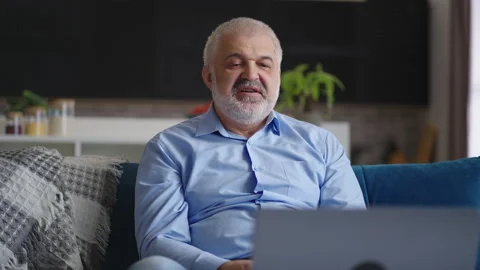 Aged man is communicating by online video chat in laptop with colleagues or Stock Footage 153513053