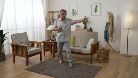 Aged man in glasses dancing alone at home Video stock 199084989