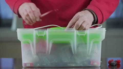 Aged man hands open plastic toolbox and put tools nearby Stock Footage 156999226