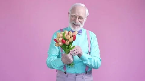 Aged man hold bunch aromatic natural flowers isolated pastel color background Stock Footage 191002611