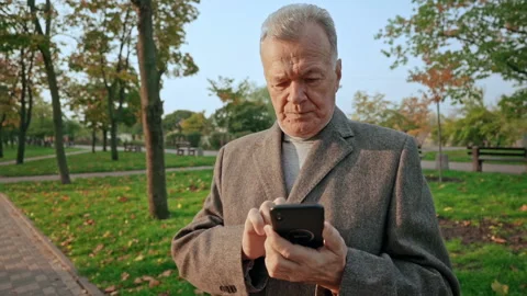 Aged man holding smartphone typing message Stock Footage 146447774